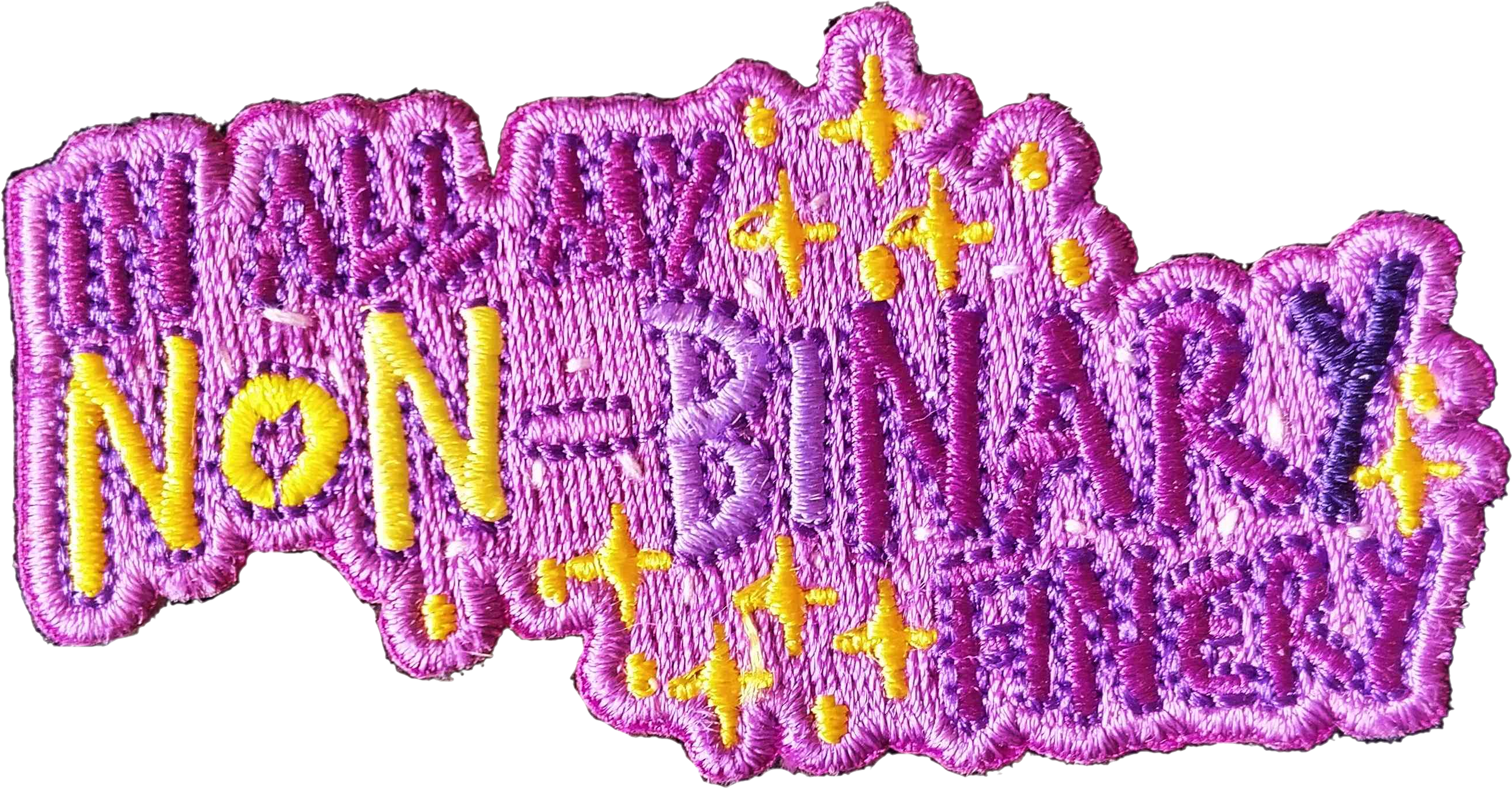 A patch in the non-binary colours with the words 'In All My Non-Binary Finery'
